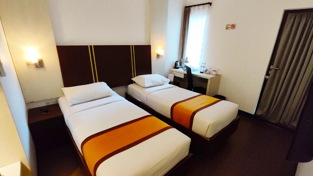 Postel nebo postele na pokoji v ubytování Odaita Hotel Pamekasan Madura