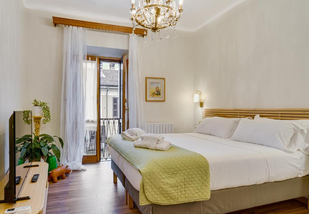 een slaapkamer met een groot bed en een kroonluchter bij San Gottardo Suites - Bamboo House in Milaan