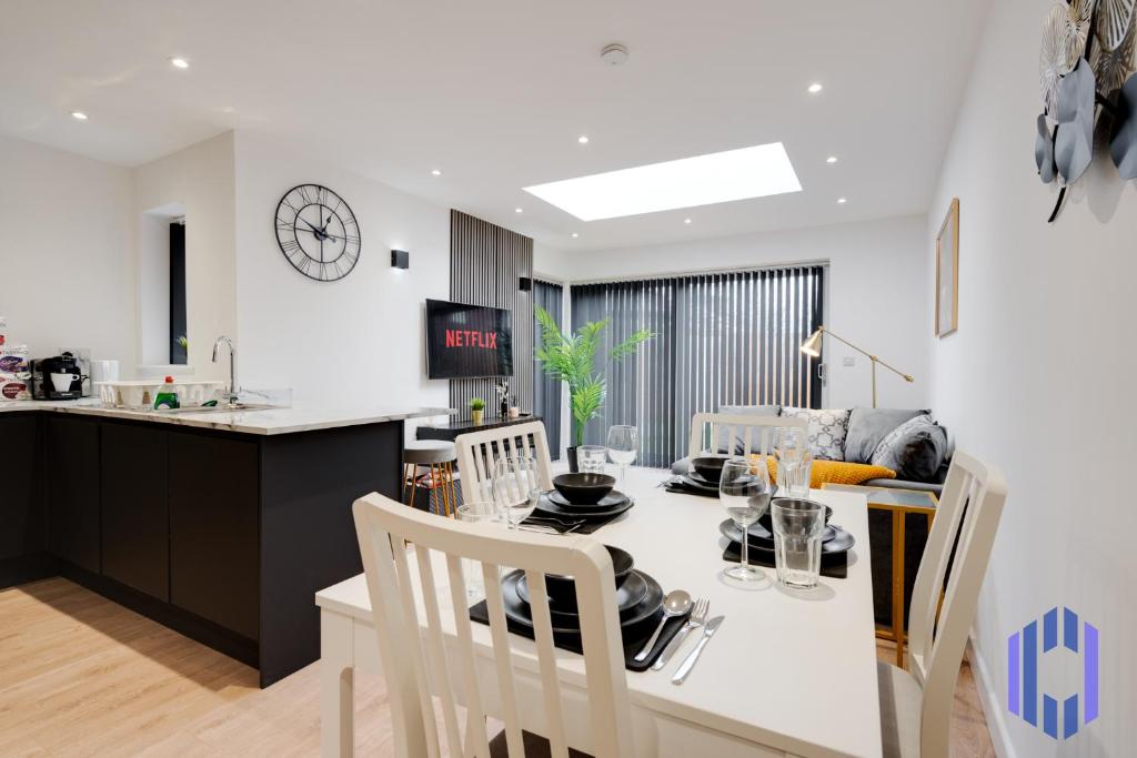 a kitchen and dining room with a table and chairs at Stylish, Modern 4 bed - Etihad - Games - Parking in Manchester