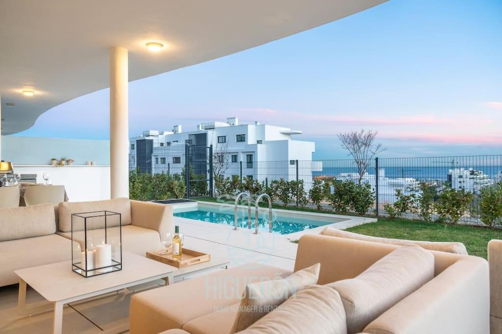 a living room with white furniture and a swimming pool at HigueronRentals Chloe by the sea in Málaga