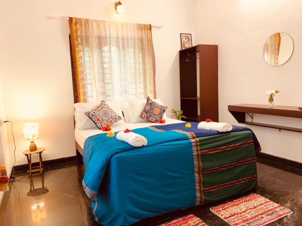 sypialnia z łóżkiem z niebieskim kocem w obiekcie Villa Mandala Guest House w mieście Varkala