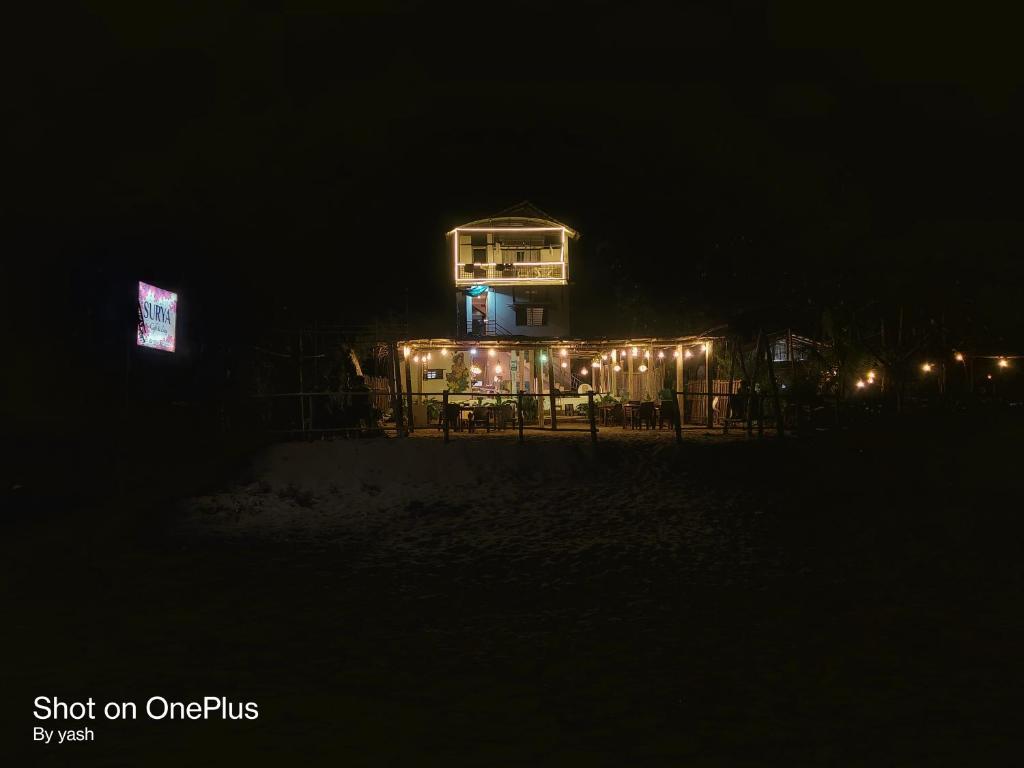 a lit up house with lights in the dark at Surya cafe and stay sea view in Gokarna