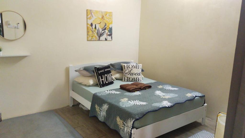 een slaapkamer met een bed met kussens erop bij Teratak Hannani Maryam Kampar ( Muslim Homestay) in Kampar