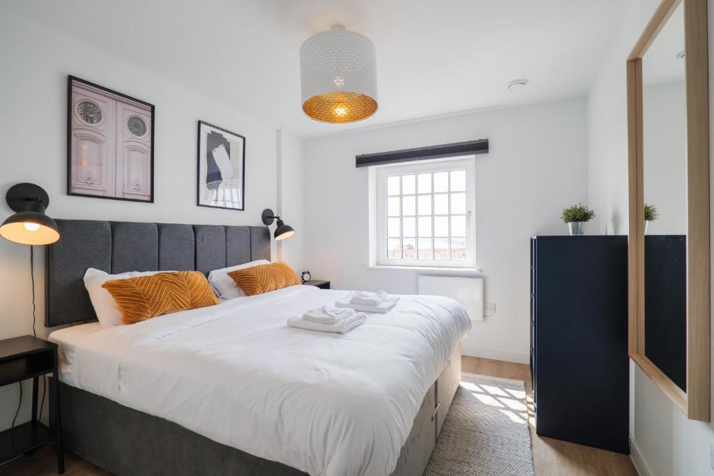 a bedroom with a large bed with orange pillows at Apartments in Cardiff in Cardiff