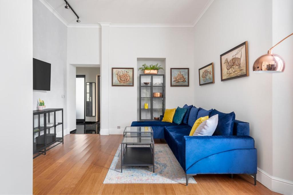 a living room with a blue couch and a table at NEW High-End 2BR Apartment with Parking in Sofia