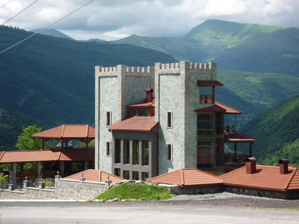 a large building with mountains in the background at Hotel Ananuri in Ananuri