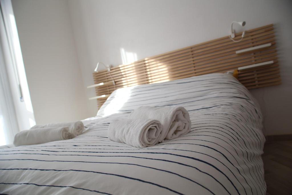 a white towel laying on top of a bed at Princess Apartment 2 - Turin - Like at Your Home in Turin