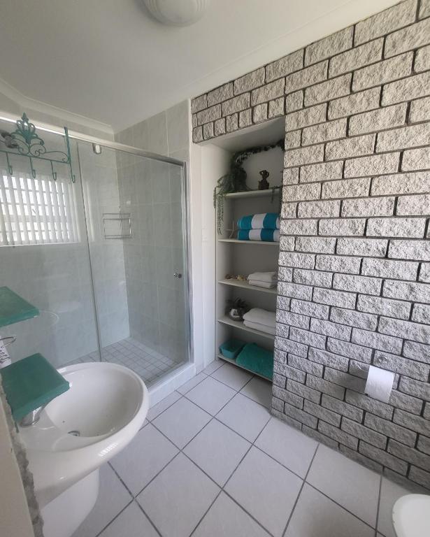 a white bathroom with a shower and a sink at APPLES APARTMENT 6B in Cape Town