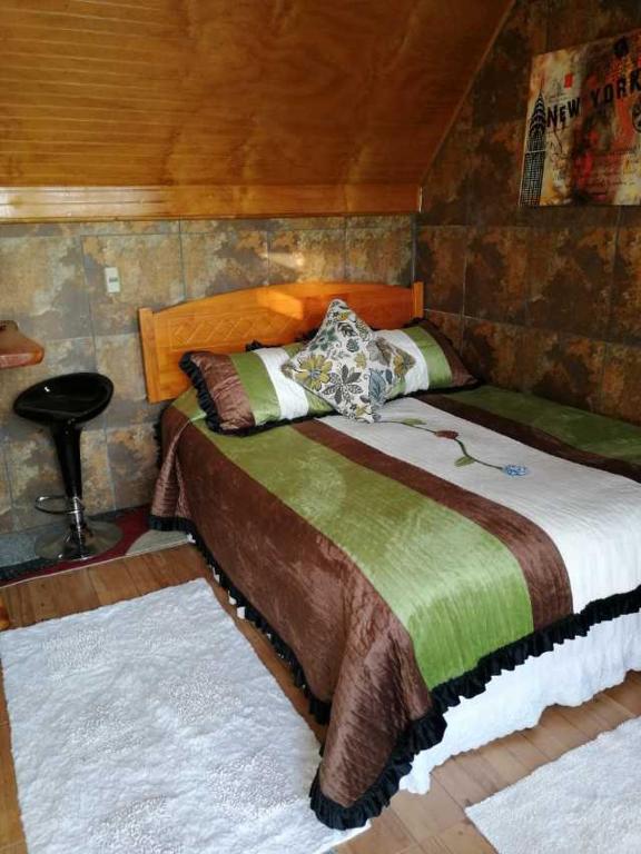 Departamentos Centro Pichilemu في بتشيلمو: غرفة نوم بسرير كبير في غرفة