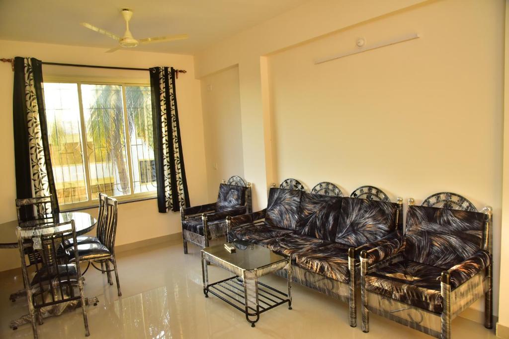 a living room with a couch and a table at Fieldstone Lovely 2 BHK AC Apartment in Talaulim