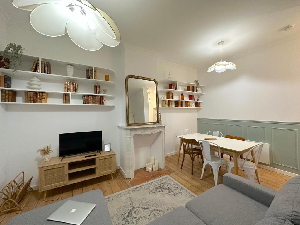 uma sala de estar com uma mesa e uma televisão em L'Artoisienne • Parking sécurisé & Wifi fibre em Douai