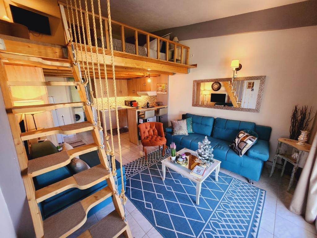 Luxury Loft Apartment Sofia في باترا: غرفة معيشة مع أريكة زرقاء وأسرّة بطابقين
