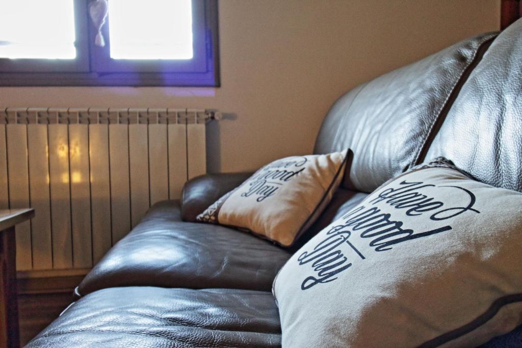 - un canapé en cuir avec 2 oreillers dans l'établissement Le Guerin - Parking et Centre, à Nîmes