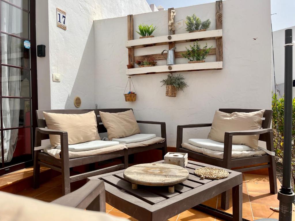 2 stoelen en een salontafel op een patio bij La Casita Sun Beach in Caleta De Fuste