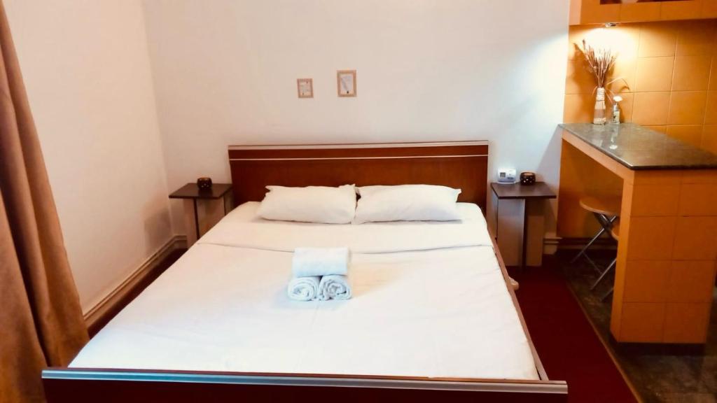 a bed in a small room with a white bed at Heart of Old Town studio with self check in in Bucharest