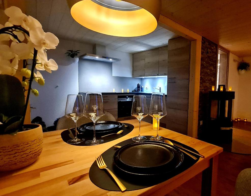 a wooden table with two glasses and a plate on it at Home & Spa 