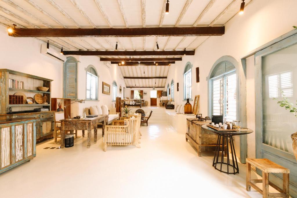 ein großes Wohnzimmer mit Tischen und Stühlen in der Unterkunft Casa La Torre Hotel Boutique in Trancoso