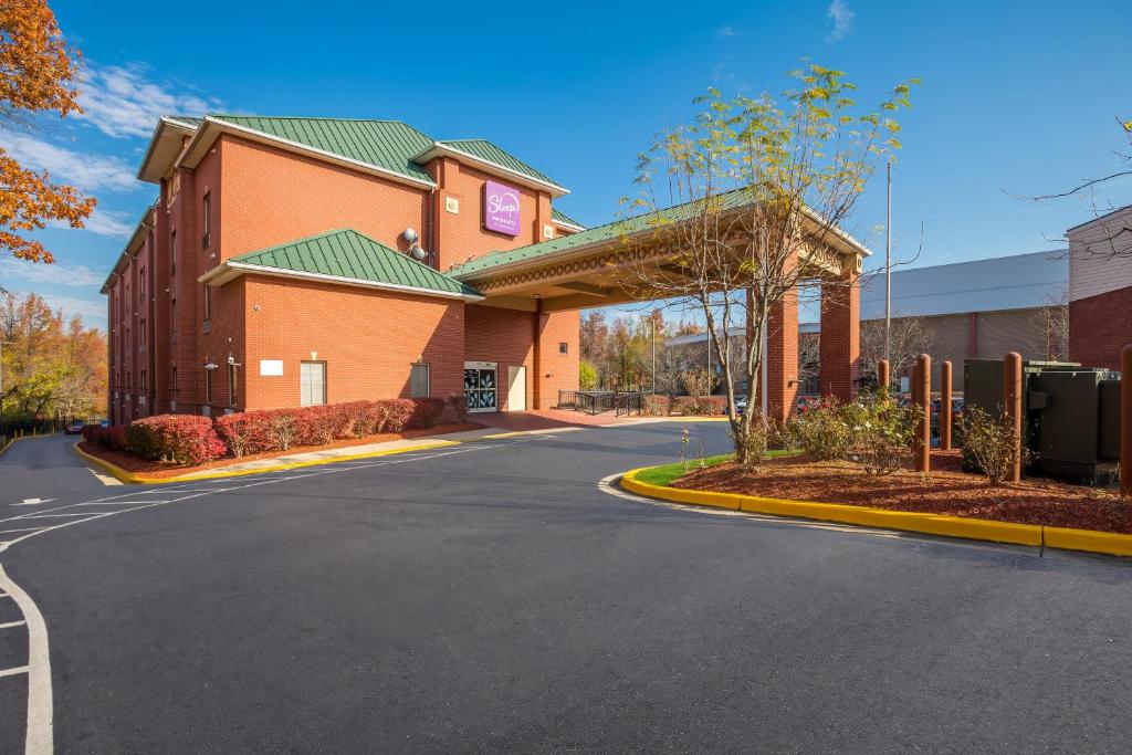 a large building with a road in front of it at Sleep Inn & Suites near Joint Base Andrews-Washington Area in Morningside