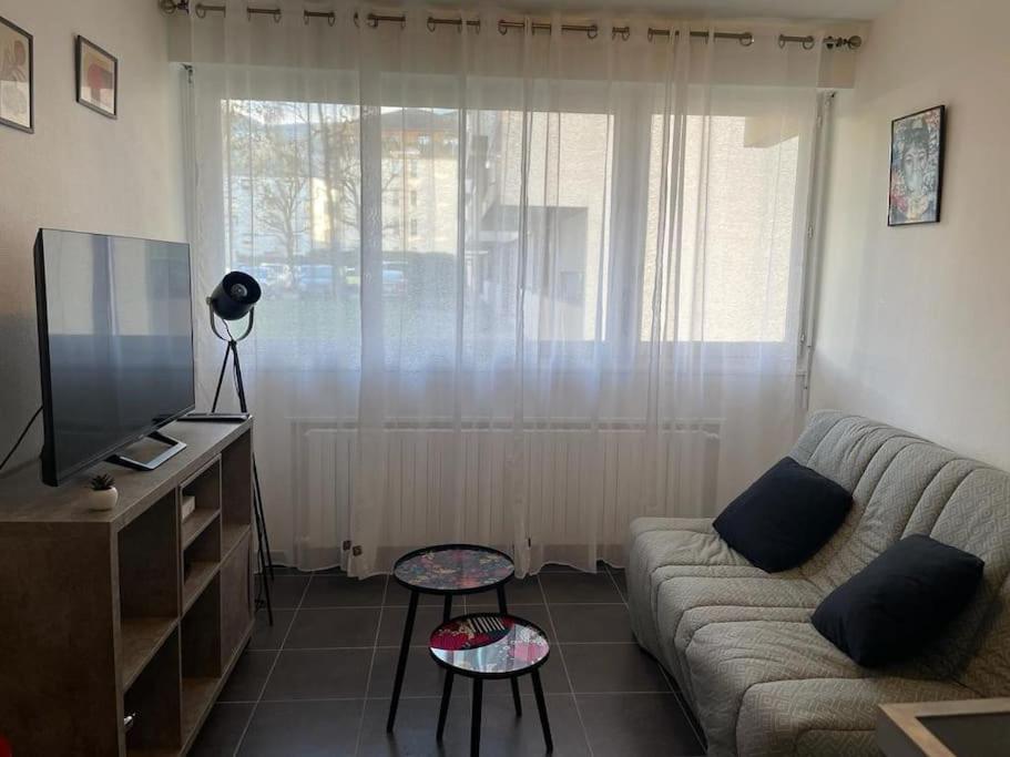 a living room with a couch and a television at LE POP ART Studio-Proche tram in Gaillard