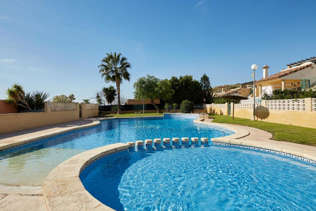 a swimming pool with blue water in a yard at Villa con vistas al mar in Alicante