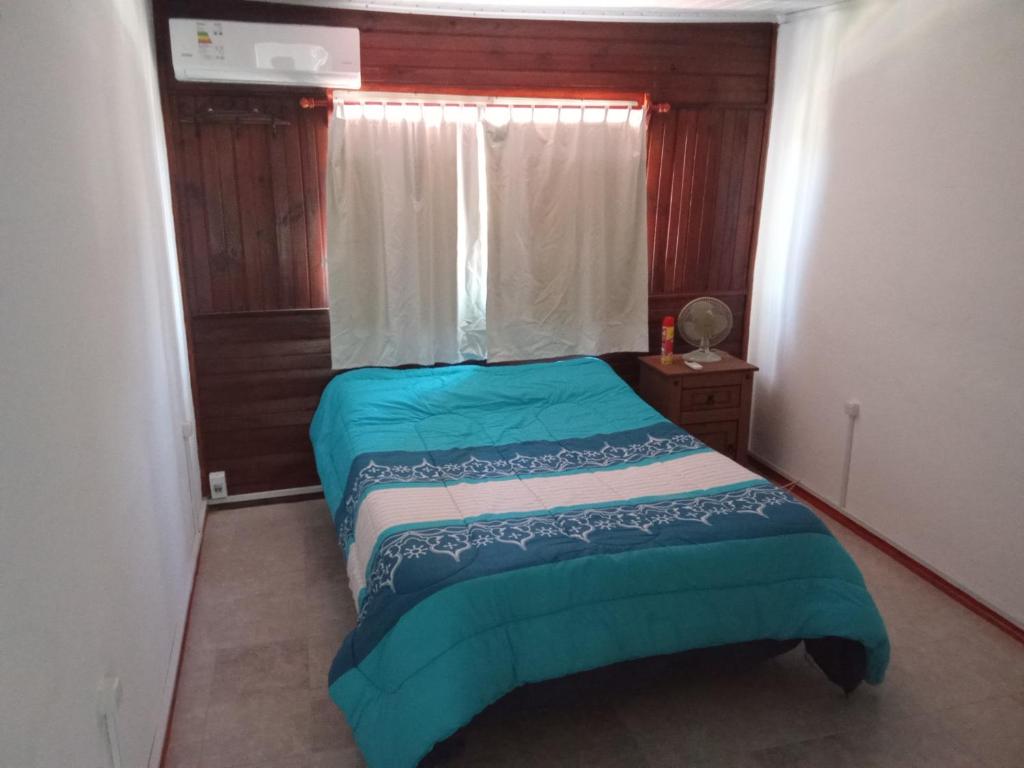um pequeno quarto com uma cama e uma janela em Apartamento amueblado en Carmelo con aire acondicionado em Carmelo