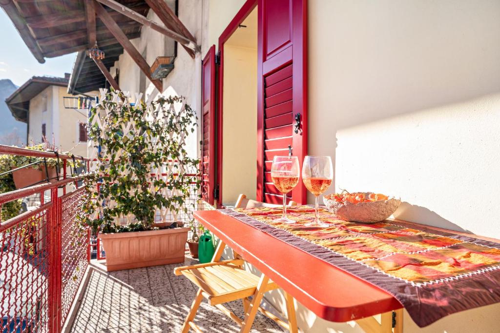 - une table avec deux verres de vin sur le balcon dans l'établissement Balconi Rossi Borgo Valsugana, à Borgo