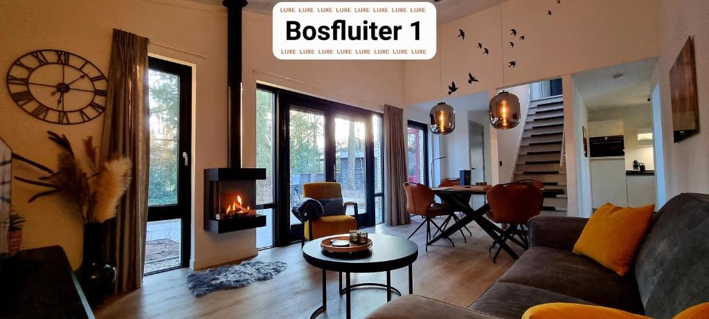 a living room with a couch and a table with a clock at Bosfluiter in Halle
