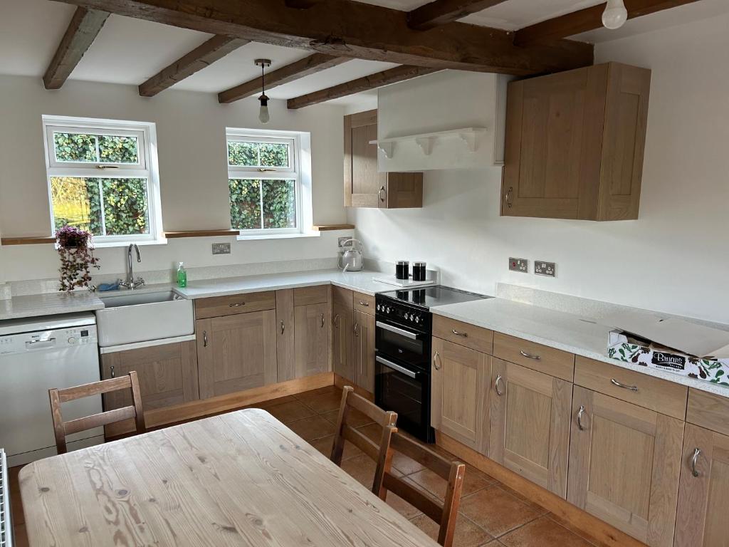 a kitchen with wooden cabinets and a wooden table with a wooden table sidx sidx sidx at The Byre in Lichfield