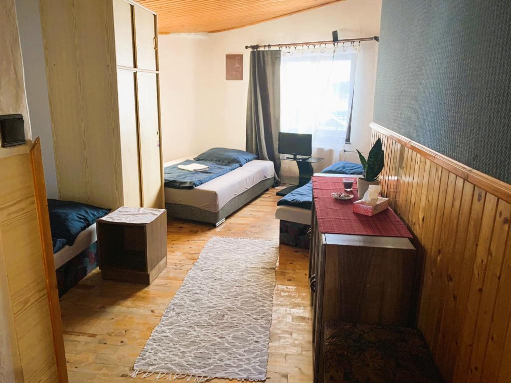 a room with two beds and a desk in it at Penzión Alex in Veľká Lomnica