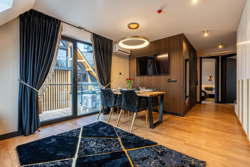 Bright open living-dining space with sliding balcony doors, dining table, velvet chairs.