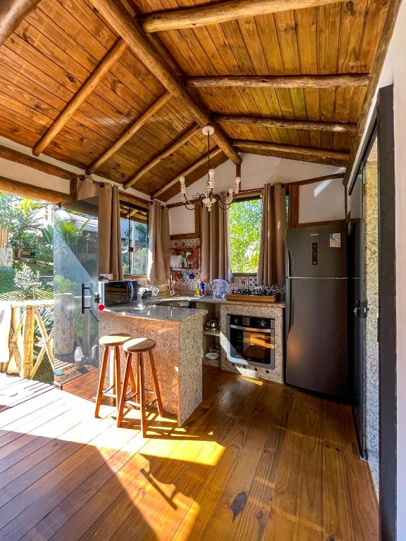 an open kitchen with a counter and a refrigerator at Chalé dos Açaís próximo à Trindade in Paraty