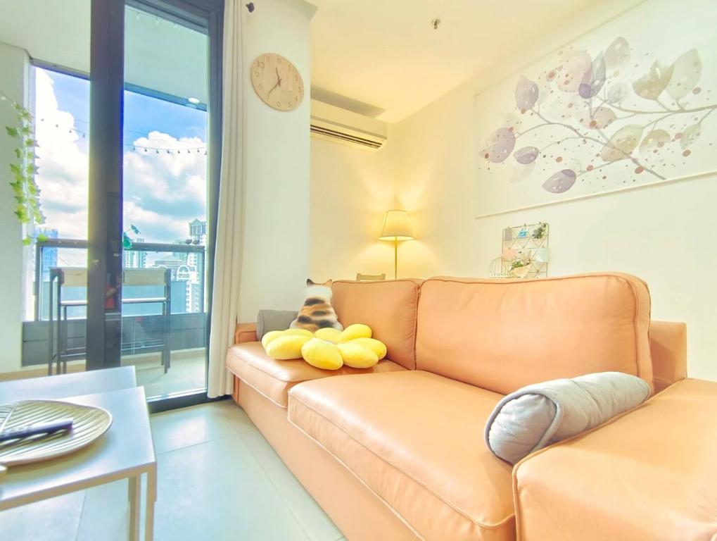een woonkamer met een bank en een groot raam bij Arcoris Suite 1-4 Pax ThePrince HighFloor/Balcony in Kuala Lumpur