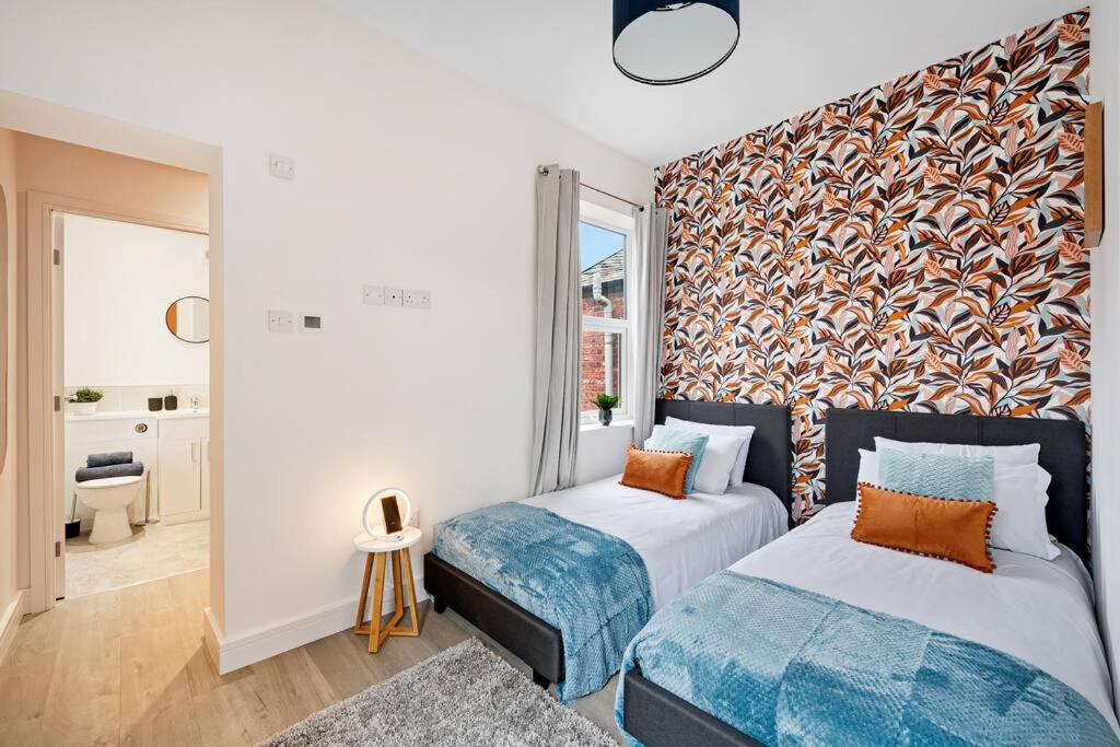 a bedroom with two beds and a large window at Stockport Retreat - Double En-suite - Great transport links - Greater Manchester in Stockport