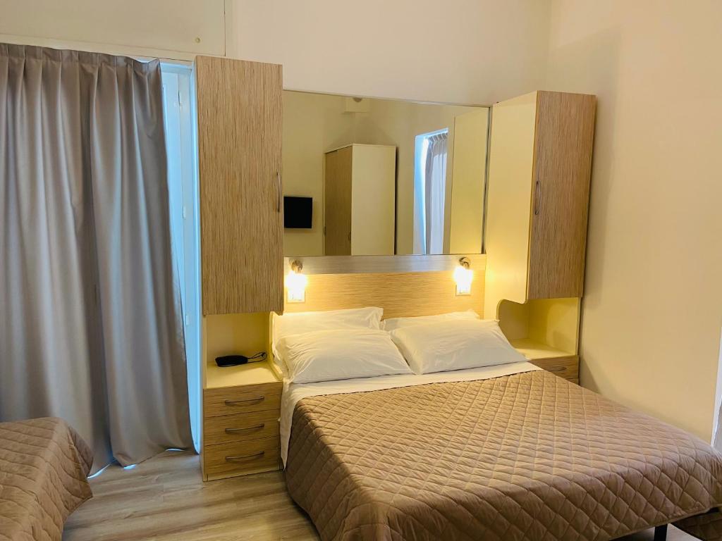 a bedroom with a bed and a mirror at Hotel Butterfly Wellness & Spa in Rimini