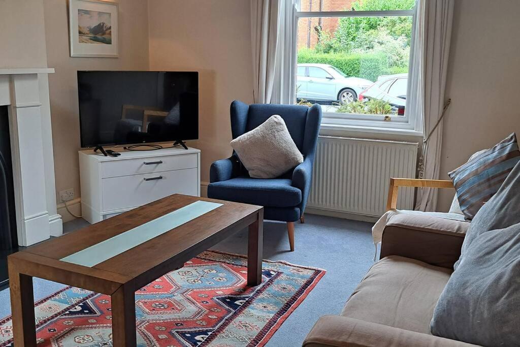 sala de estar con TV, sofá y mesa en Stunning 3BD Victorian House in Bramhall Village en Bramhall