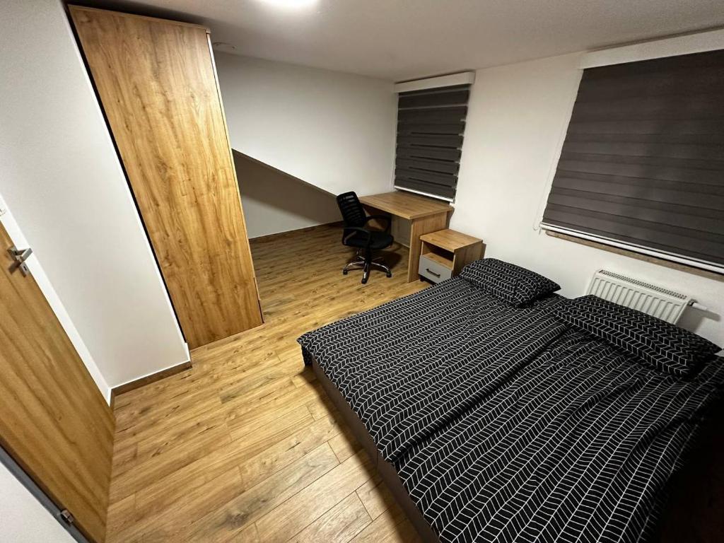 1 dormitorio con cama, escritorio y puerta en Double Twin Room #4 with Private Bathroom, en Varsovia