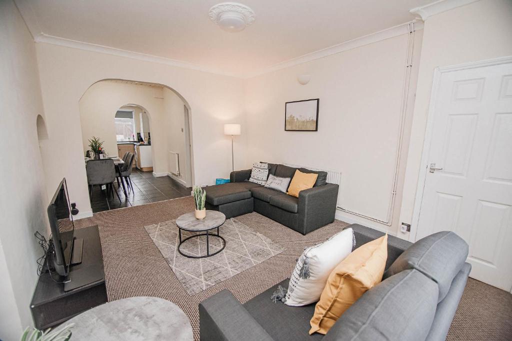 uma sala de estar com um sofá e uma televisão em K Suites - Arthur Street Doncaster em Bentley