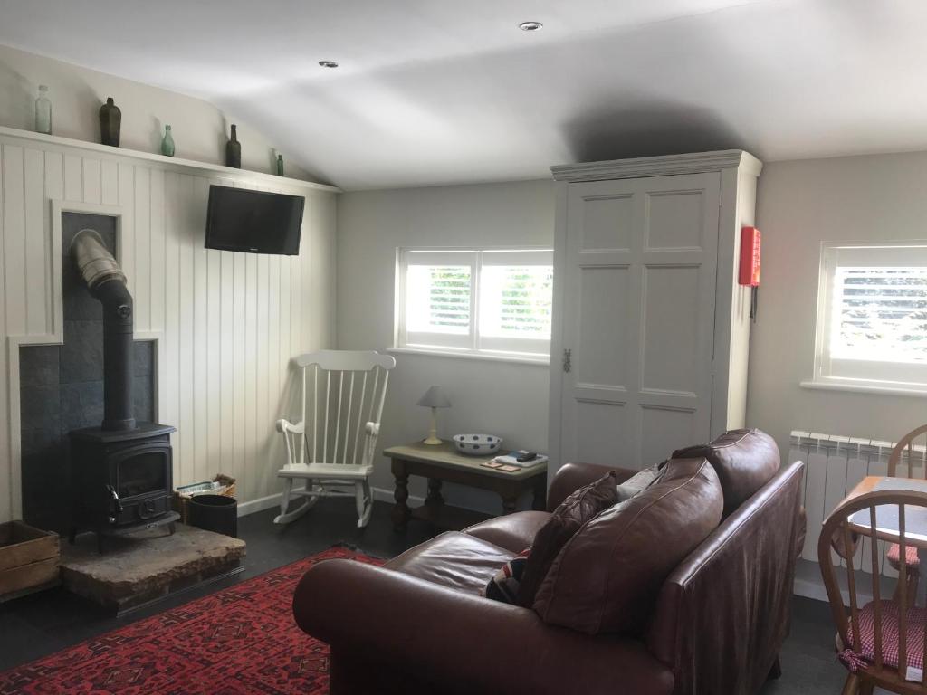 a living room with a couch and a wood stove at The Stable in Stourbridge