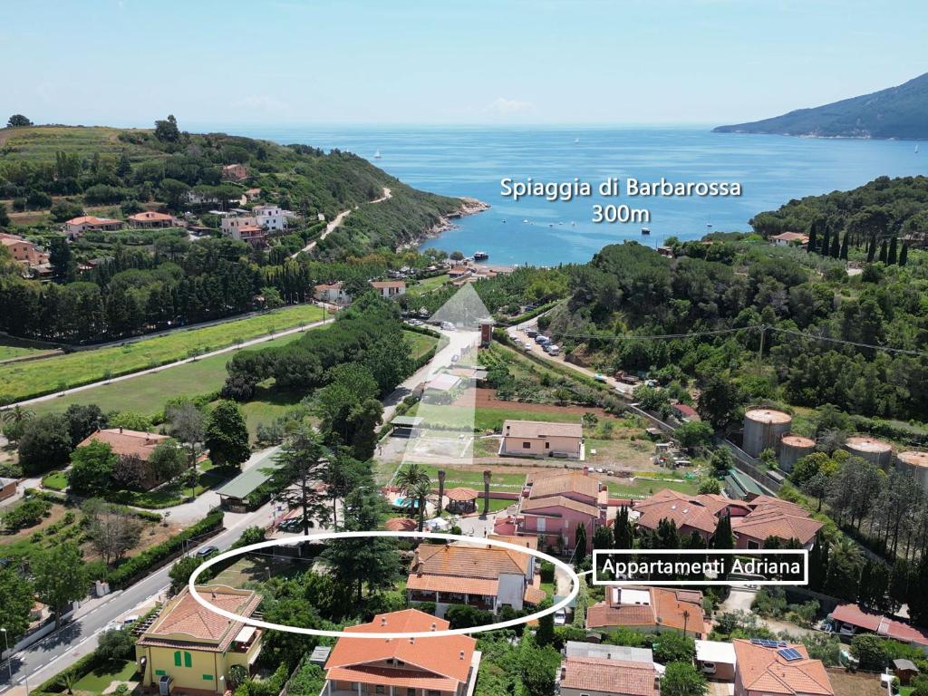 arial view of a town with a road and a lake at Appartamenti Adriana di ArgonautiVacanze in Porto Azzurro