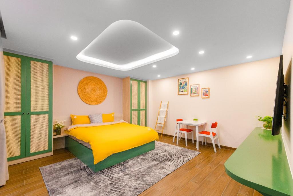 a bedroom with a yellow bed and a table at Pavillon Garden Hotel & Spa Nha Trang in Nha Trang