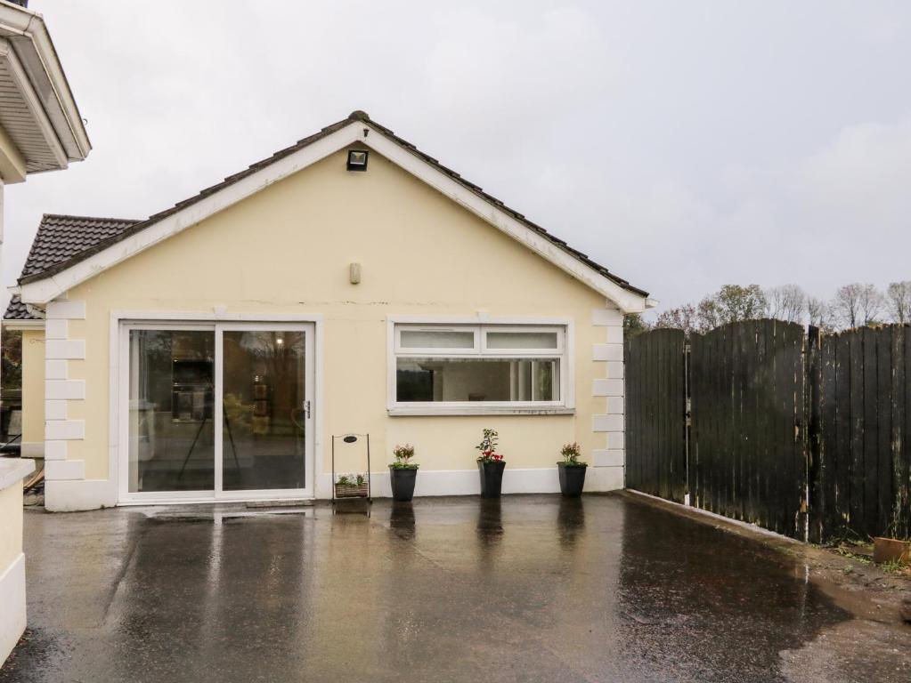 una casa blanca con una valla y macetas en 19A Lismenary Road, en Ballyclare