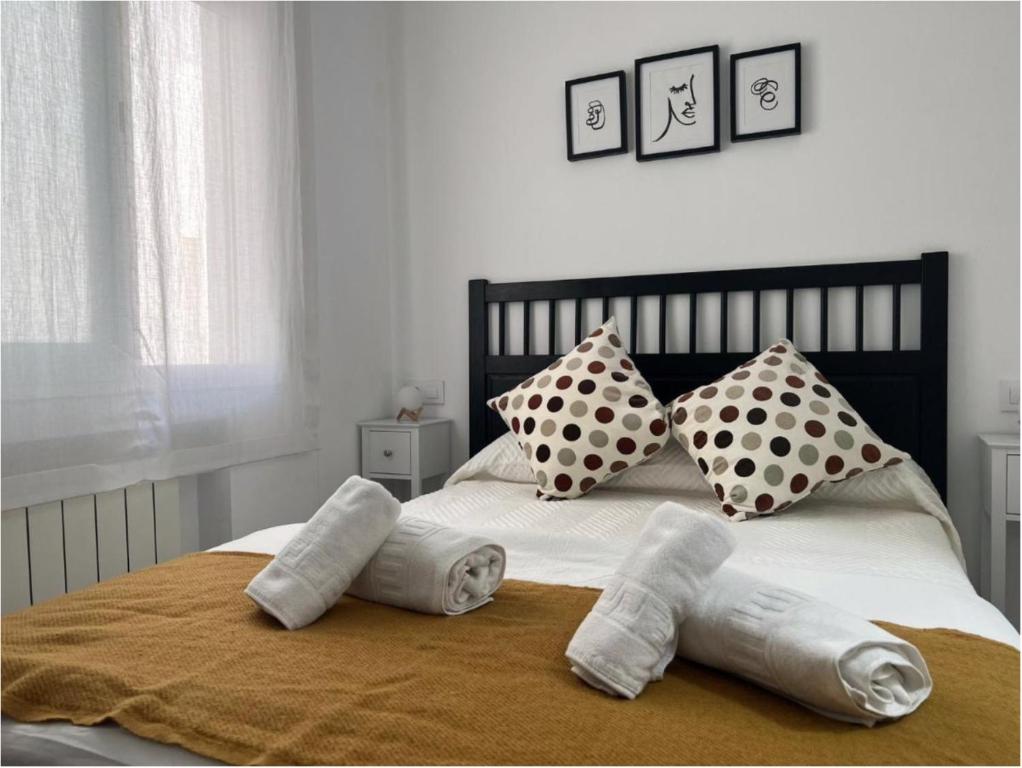 a bed with four pillows and towels on it at APARTAMENTO URQUÍA in Córdoba