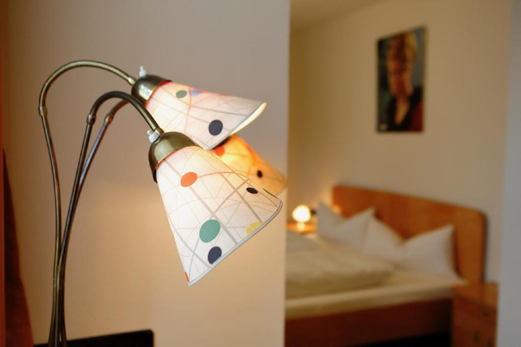 a lamp in a hotel room with a bed at Gasthof Krone Fladungen in Fladungen
