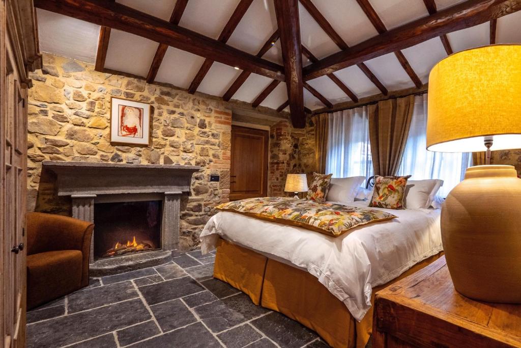 a bedroom with a bed and a fireplace at La Tuscia - Tenuta Di Toscana, Boutique Villa in Gaiole in Chianti
