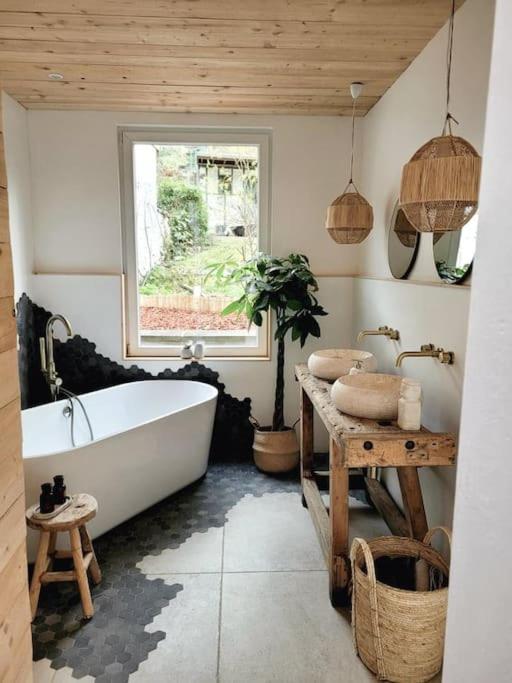 ein Bad mit einer Badewanne und einem Fenster in der Unterkunft Superbe appartement avec cheminée in Verviers