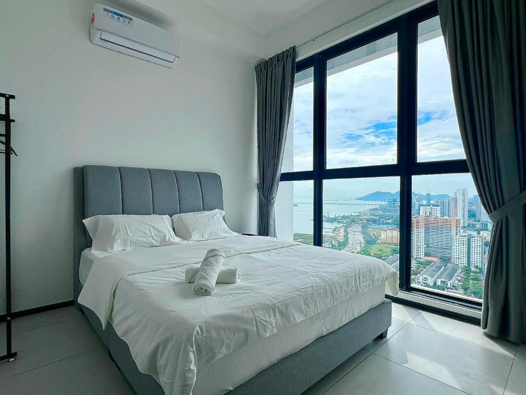 Un dormitorio con una cama grande con una ventana grande. en Urban Suites - George Town, Penang, en Jelutong