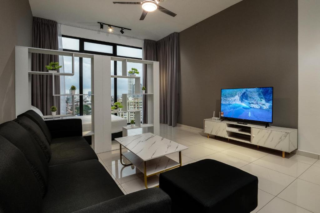 uma sala de estar com um sofá e uma televisão de ecrã plano em Penang KTHOME Beacon Executives suite em George Town