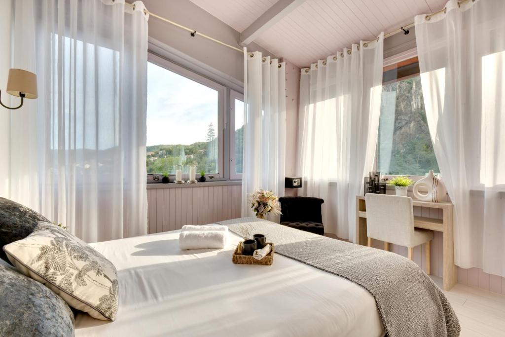 um quarto com uma grande cama branca e uma janela em Hôtel Les Sources em Vernet-les-Bains