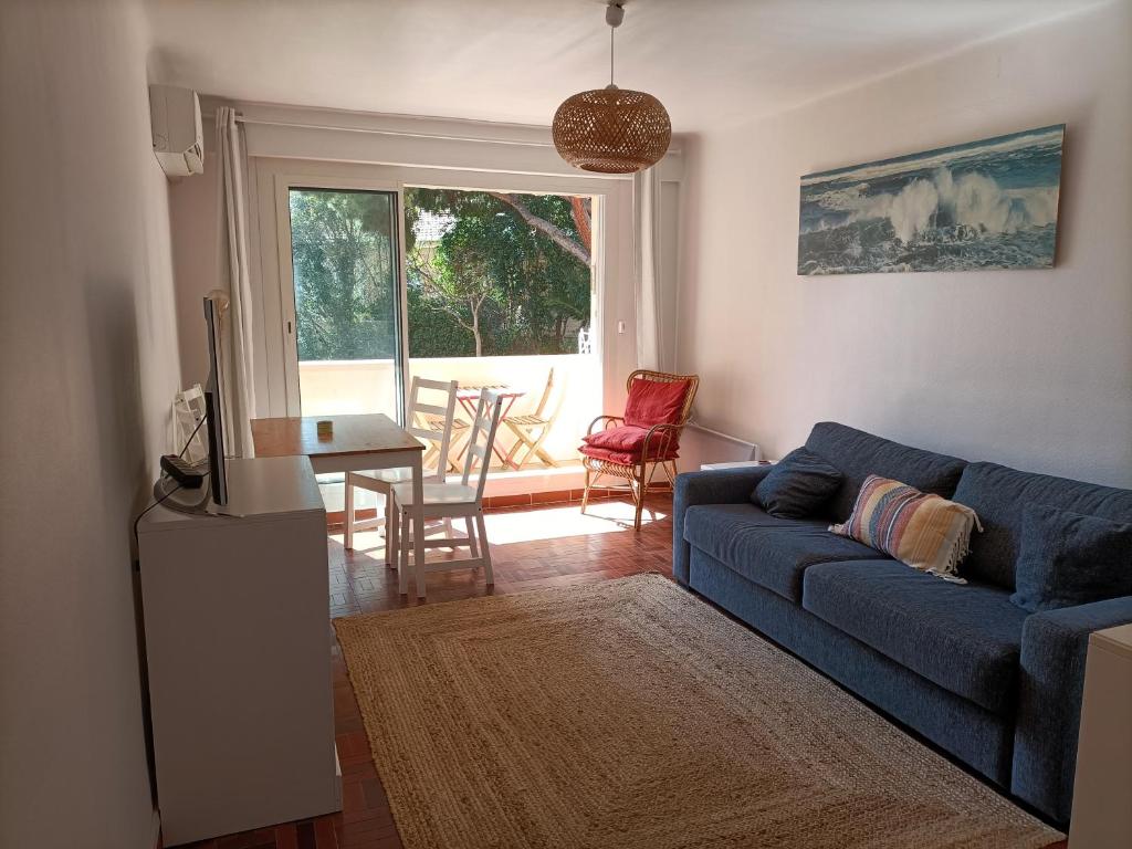 un salon avec un canapé bleu et une table dans l'établissement T2 à 50 mètres de la mer, à Saint-Cyr-sur-Mer