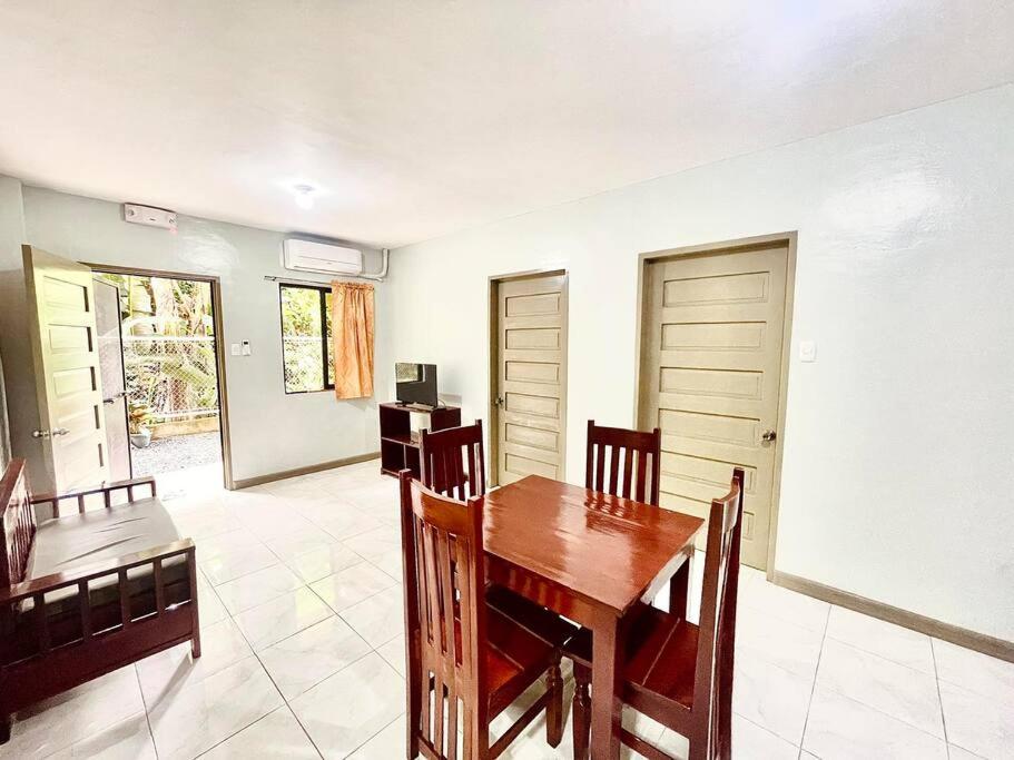 a dining room with a wooden table and chairs at M & M 's Home Stay in Puerto Princesa City